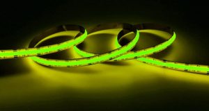A lit up yellow-green strip light in a dark room.
