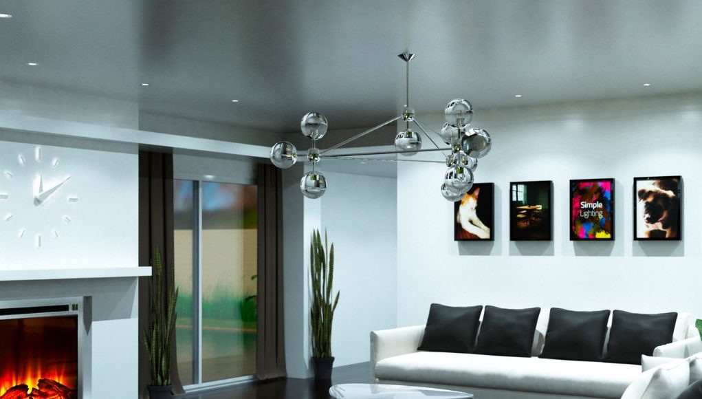 A living room with white sofa and black pillows and a silver hanging statement light.