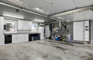 A wide garage with a clean and organised shelving on the walls.