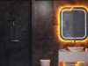 Creative LED Strip Lighting Ideas for Every Room in Your Home A dark bathroom with white sink and a mirror with orange backlighting.