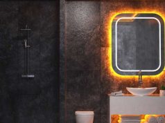 Creative LED Strip Lighting Ideas for Every Room in Your Home A dark bathroom with white sink and a mirror with orange backlighting.