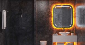 A dark bathroom with white sink and a mirror with orange backlighting.