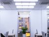 An office with windows overlooking a city, its ceiling is installed with multiple tube lights.