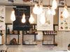 Image of a cafe menu with multiple warm light bulbs hanging from the ceiling.
