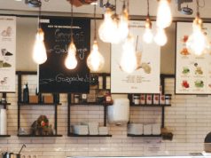Image of a cafe menu with multiple warm light bulbs hanging from the ceiling.