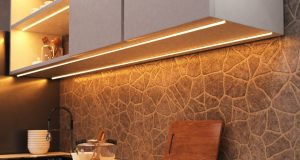 A kitchen countertop with visible under-cabinet LED strip lights with a warm glow.