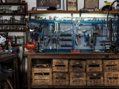 How to Turn Your Garage into the Perfect DIY Workshop A garage workshop with a lot of tools hanging on the wall.