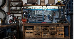 A garage workshop with a lot of tools hanging on the wall.