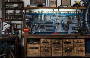 A garage workshop with a lot of tools hanging on the wall.