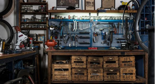 How to Turn Your Garage into the Perfect DIY Workshop A garage workshop with a lot of tools hanging on the wall.
