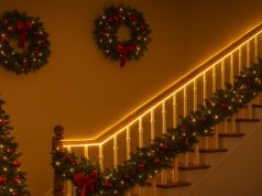 A staircase with its hand rail lit up by LED strip lights.