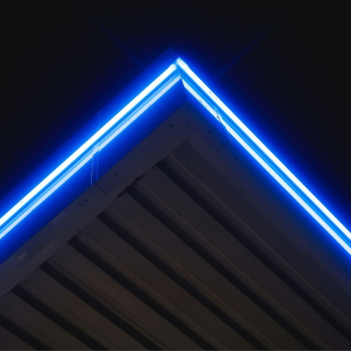 A roof corner edge where blue LED neon light is seen glowing brightly.