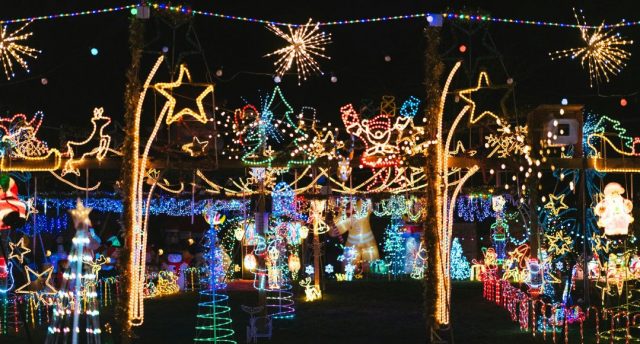 A lot of random glowing Christmas decorations outdoors.