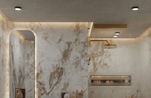 A modern bathroom with marble walls and warm ceiling and mirror lighting.