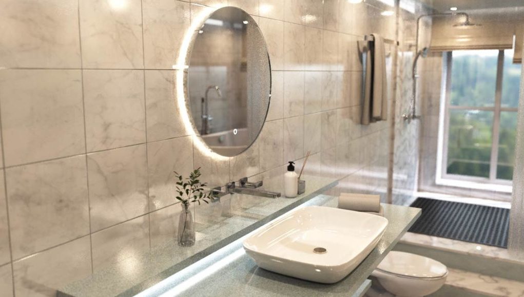 A modern bathroom with a round LED mirror over a vanity, and the shower area is behind a glass partition.