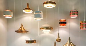 Multiple hanging lights illuminating a white wall.