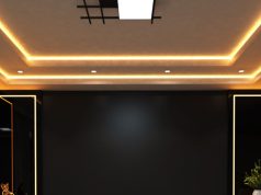 A living room ceiling with a statement centre light and warm strip lights along the ceiling coves.
