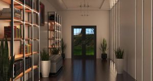 A hallway with illuminated shelving to the left side and an unlit statement pendant in the middle of the ceiling.