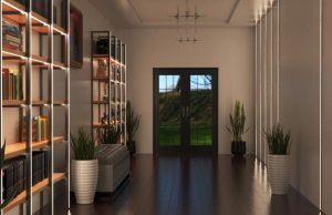 A hallway with illuminated shelving to the left side and an unlit statement pendant in the middle of the ceiling.