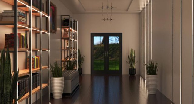 A hallway with illuminated shelving to the left side and an unlit statement pendant in the middle of the ceiling.