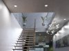 A modern home stairs with multiple LED downlights and pendants around the lower ground ceiling.