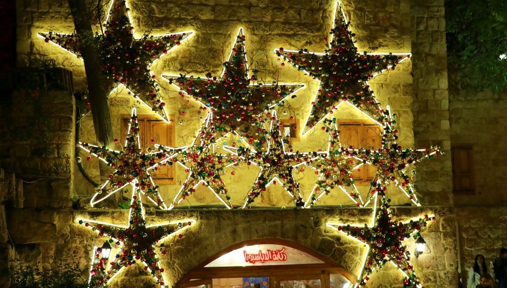 A wall adorned with star ornaments lined with LED neon lights.