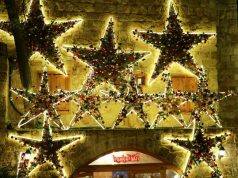 A wall adorned with star ornaments lined with LED neon lights.