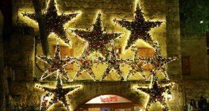 A wall adorned with star ornaments lined with LED neon lights.