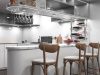 A modern kitchen with an island/bar area and bar stools, under-cabinet lights are illuminating the space.