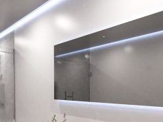 Minimalist Lighting Ideas That Make Any Home Look More Contemporary A bright modern bathroom with a large horizontal mirror and ceiling strip lighting.