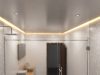 A modern bathroom with warm LED strip lights installed on the ceiling perimeter, along with some downlights evenly spaced throughout.