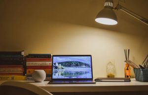 Smart Lighting Ideas for Home Offices to Reduce Eye Strain and Improve Focus A home office desk illuminated by a single desk lamp with warm white tone.