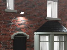 Smart Lighting for Home Security Using PIR Sensors and LED Floodlights A UK home facade with brick walls and floodlights installed glowing with bright white light.