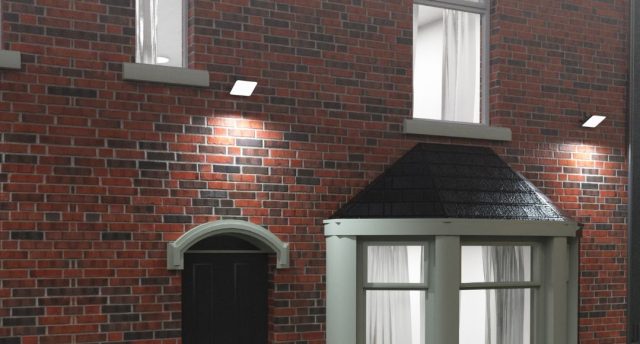 A UK home facade with brick walls and floodlights installed glowing with bright white light.