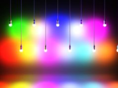 Using RGB and CCT LED Lighting to Transform Your Home in 2026 Two rows of lights with different colours hanging in two different heights in a dark room.