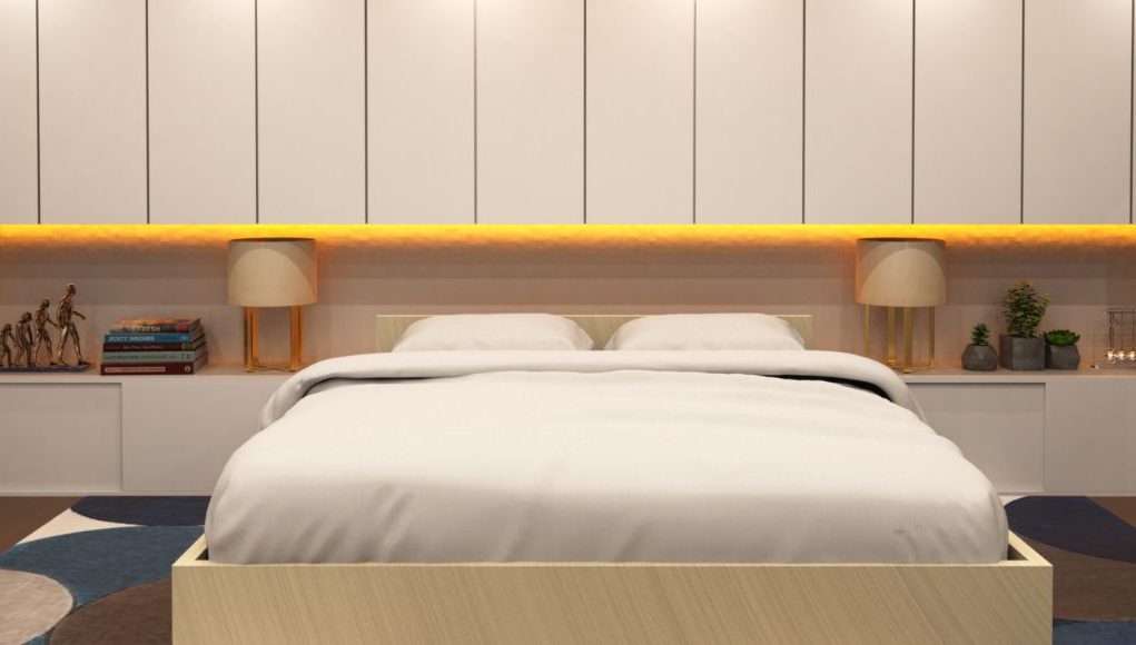 A bedroom with a beige theme and yellow under cabinet lighting.
