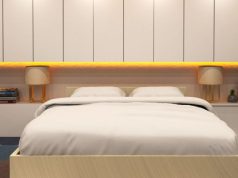 Ways LED Strip Lights Can Modernise Bedrooms, Media Walls, and Storage Spaces A bedroom with a beige theme and yellow under cabinet lighting.