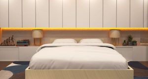 A bedroom with a beige theme and yellow under cabinet lighting.