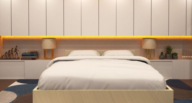 A bedroom with a beige theme and yellow under cabinet lighting.