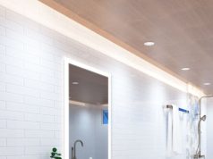 A bright bathroom with a wooden ceiling installed with LED downlights and warm LED strips around the perimeter.