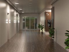 A hotel hallway with multiple rooms illuminated by round bulkhead lights.