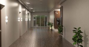 A hotel hallway with multiple rooms illuminated by round bulkhead lights.