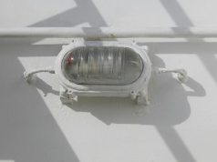 ATEX Zone Lighting: Hazardous Area Classification & LED Solutions A bullhead installed on a wall just below a pipe, painted white as the wall.