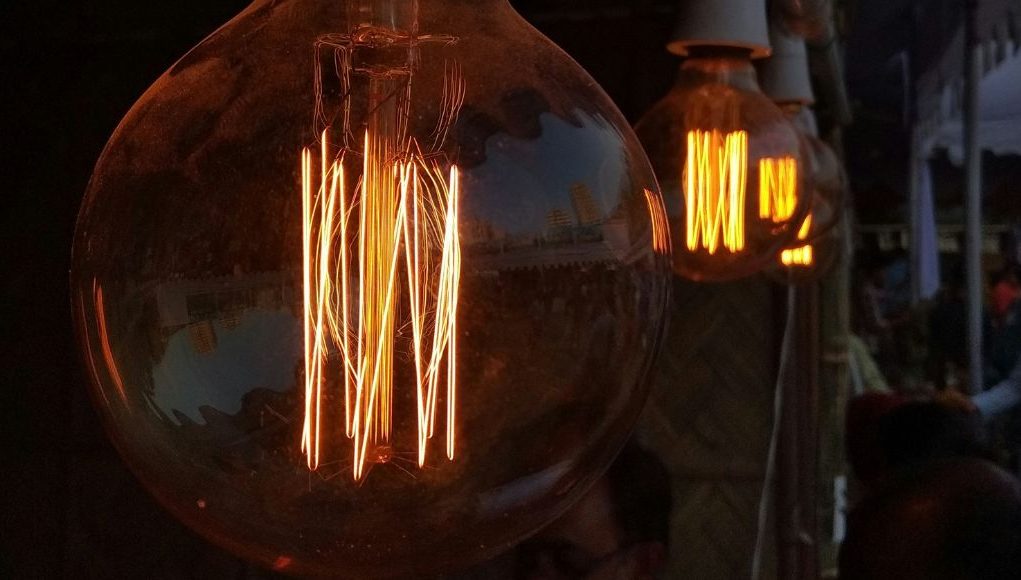 What Is the Brightest LED Filament Bulb hero Multiple filament bulbs glowing with an amber hue.