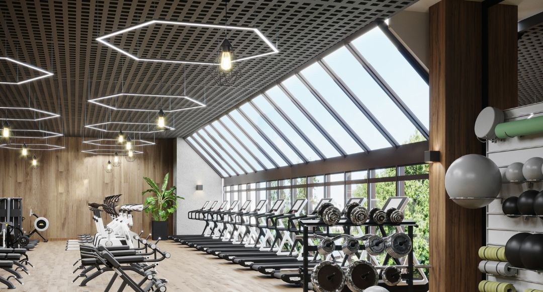 A bright gym treadmill area with big windows and multiple LED lighting on the ceiling.