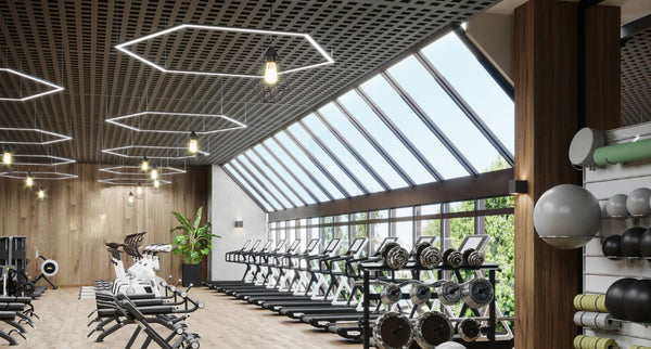 A bright gym treadmill area with big windows and multiple LED lighting on the ceiling.