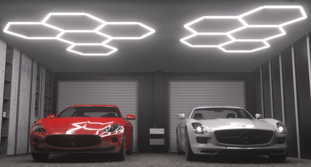 A red and white supercar in a double garage illuminated by two sets of hexagon lights.