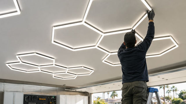 A man installing hexagon LED lights in a garage