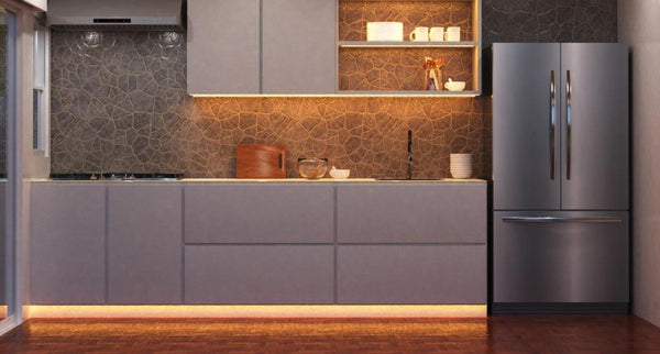 Modern minimalist kitchen illuminated by multiple warm LED strip lights in shelving, under cabinet, and plinth.