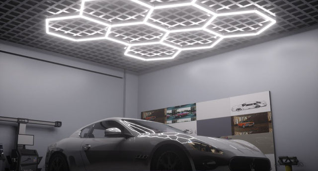 A modern garage illuminated by a set of multiple hexagon lights just right above a parked car.